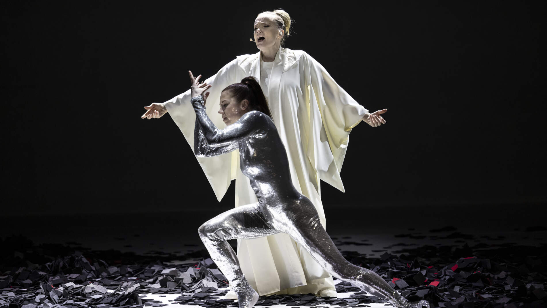 Ane Brun står och sjunger i en lång vit sidenrock. En dansare i silverfärgad trikå dansar framför henne. Svarta rutor av silkespapper är utspridda på golvet.