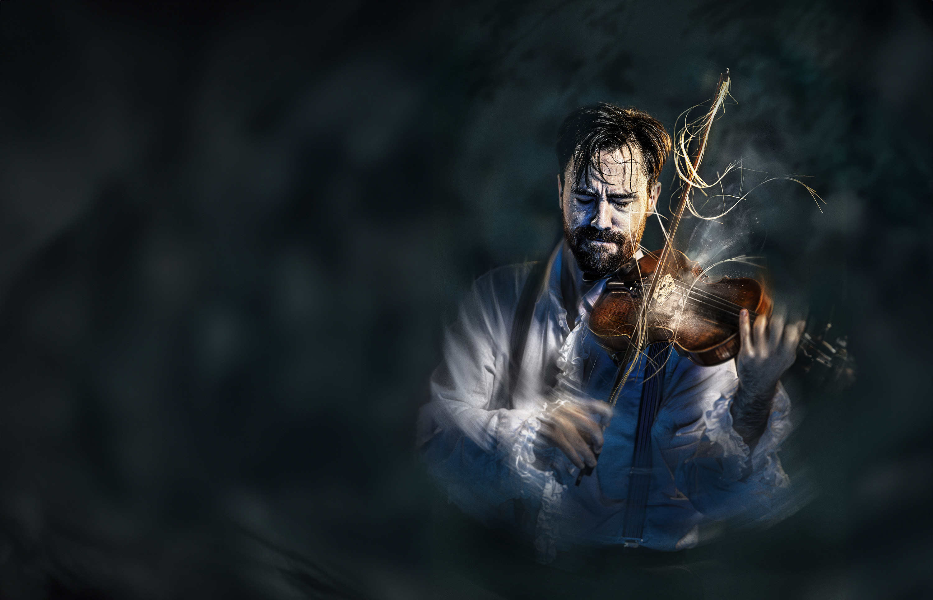 En svettig violinist står i rampljus och spelar så intensivt att hans armar är suddiga. Några hårstrån har lossnat på stråken