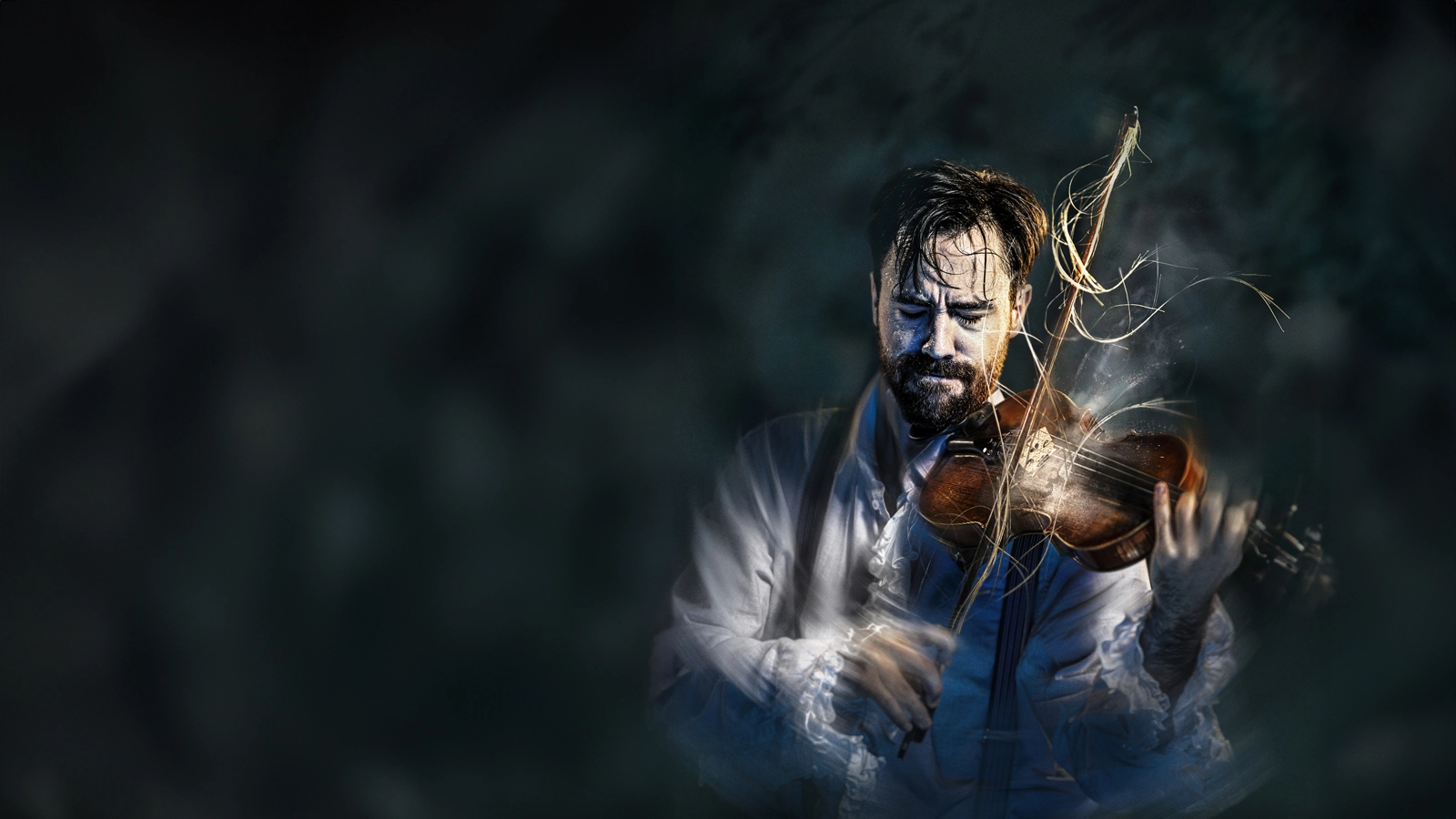 En svettig violinist står i rampljus och spelar så intensivt att hans armar är suddiga. Några hårstrån har lossnat på stråken