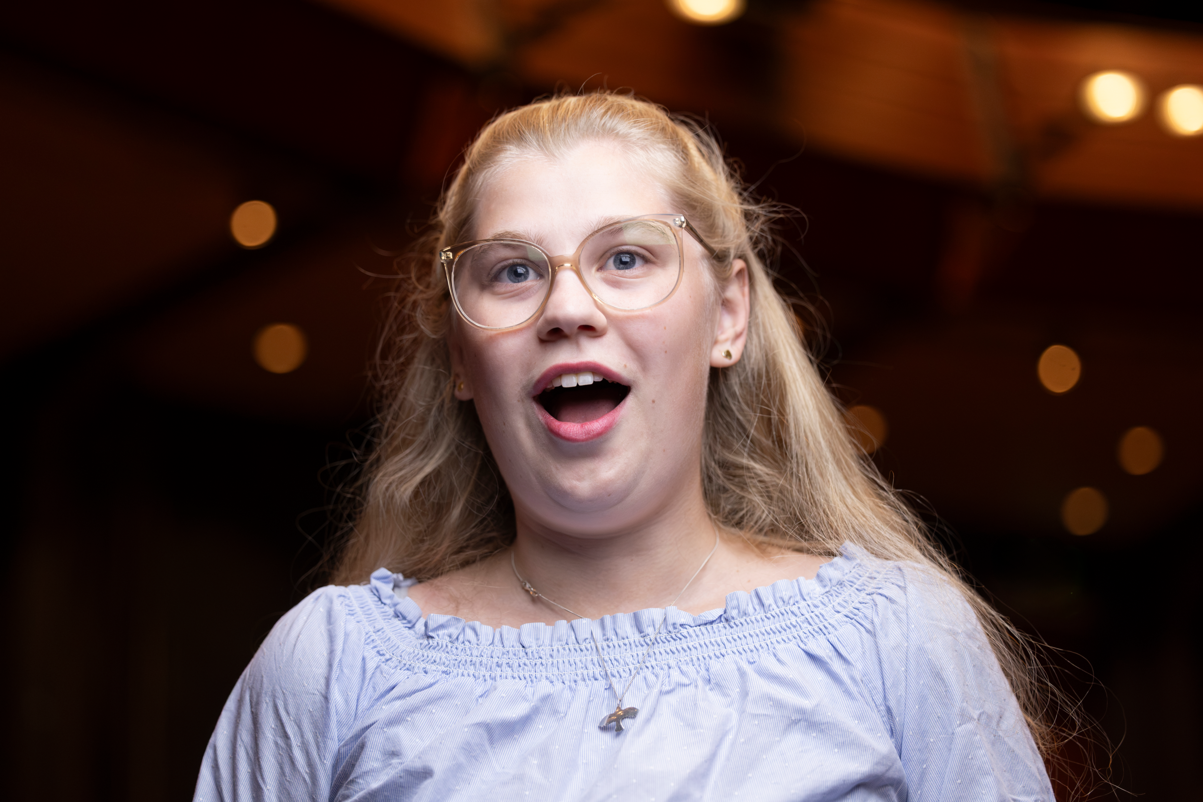 En ungdom i teatersalong betraktar vad som sker på scen med ett förtjust ansiktsuttryck.