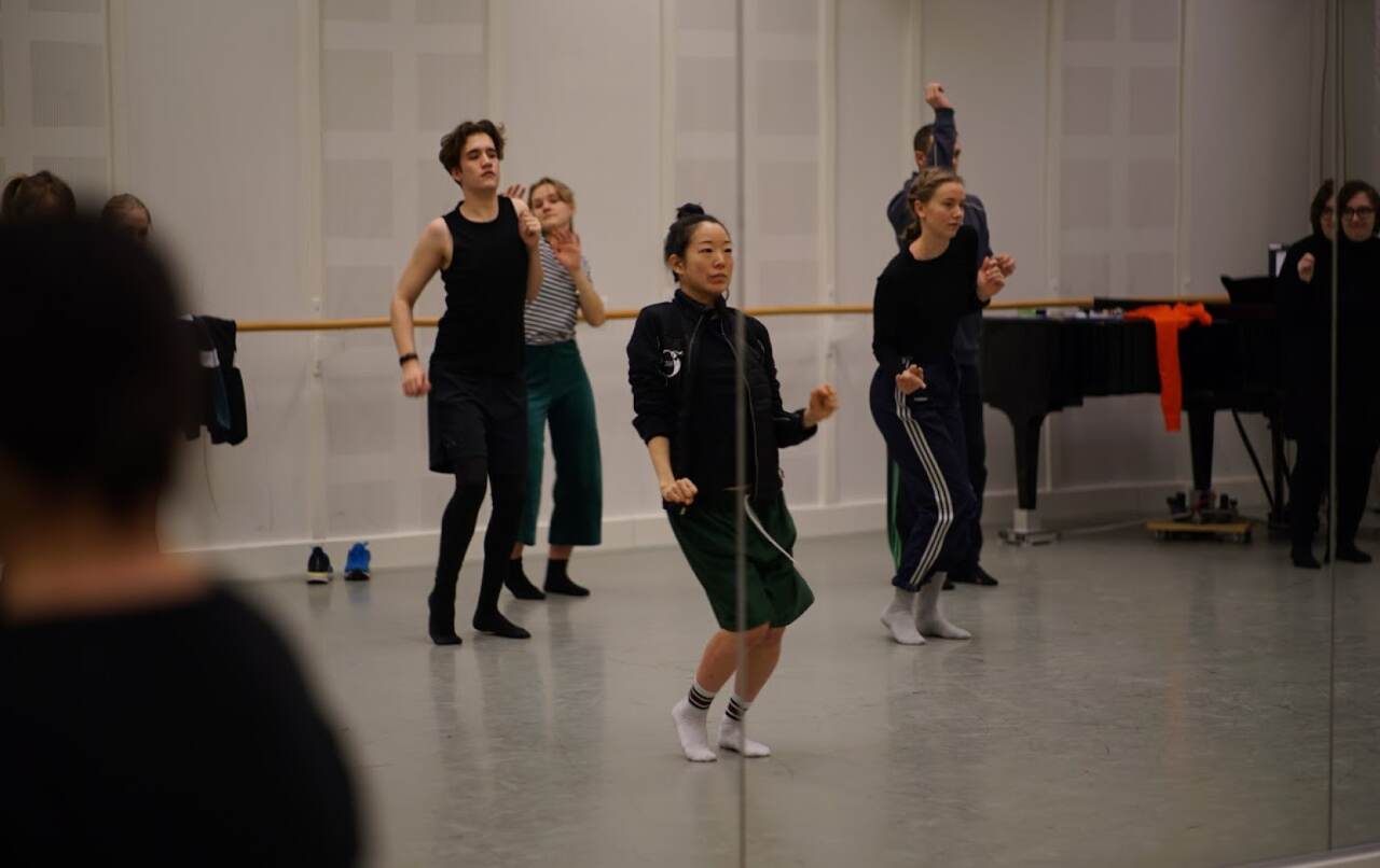 Flera elever dansar uttrycksfullt i ett repetitionsrum.