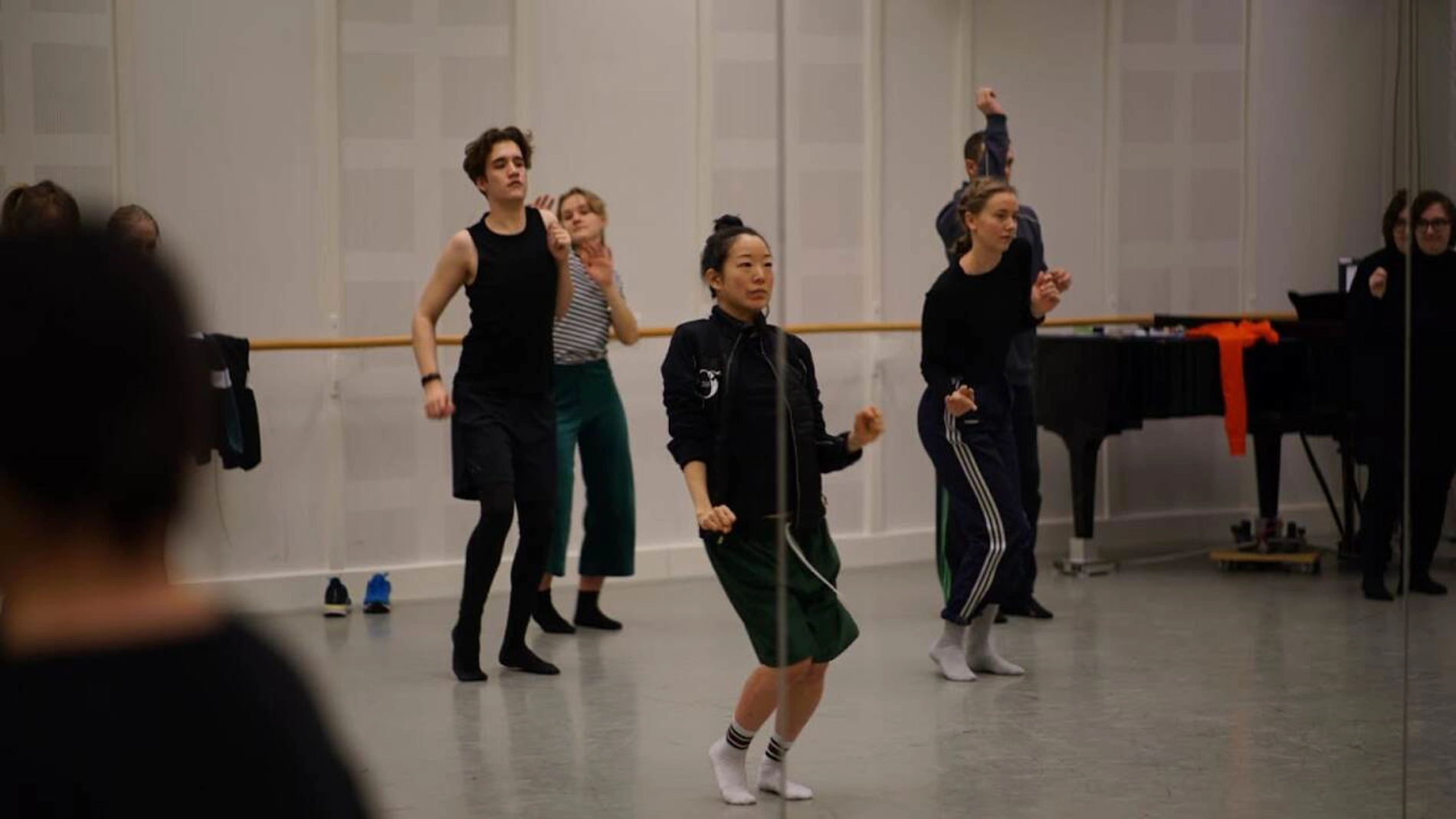 Flera elever dansar uttrycksfullt i ett repetitionsrum.