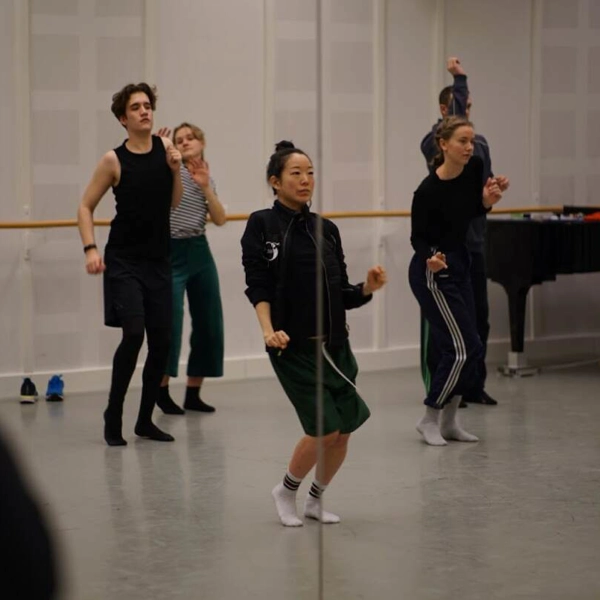 Flera elever dansar uttrycksfullt i ett repetitionsrum.