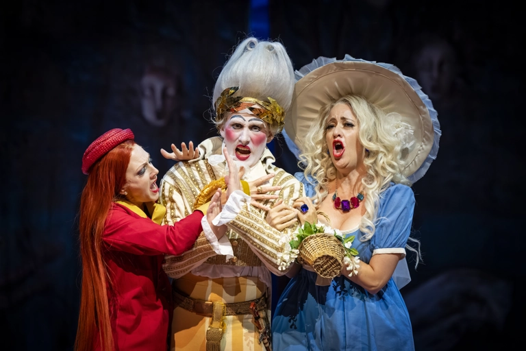 Dandini står omringad av Clorinda och Thisbe, som har armarna knäppta om honom. Alla sjunger med irriterade ansiktstuttryck.