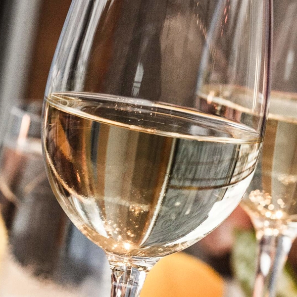 En närbild av två vinglas som innehåller vitt vin.