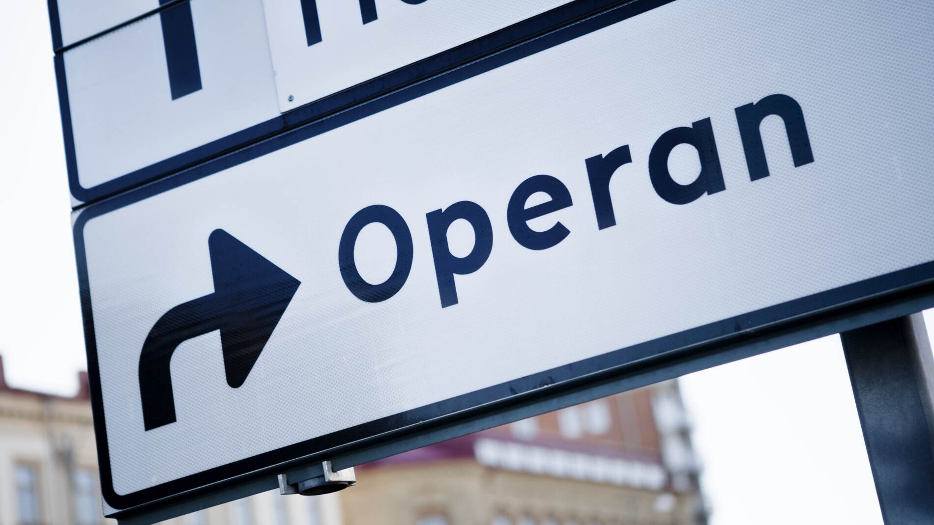 Närbild av en stadsgatuskylt som visar en pil som pekar mot "Operan".
